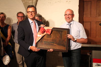 Bild vergrößern: Bürgermeister Gerd Muhle (rechts) überreicht ein Gemälde des historischen Ratssaals an Bürgermeister Joachim Coens 