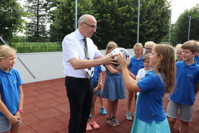 Bild vergrößern: Bürgermeister Gerd Muhle hatte für die Kinder einen Fußball für die Fußballbox mitgebracht