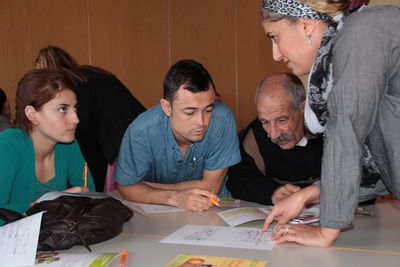 Bild vergrößern: Scherin Silli (rechts) erklärt Arabisch sprechenden Flüchtlingen als Dolmetscherin das Moobil+-Bussystem